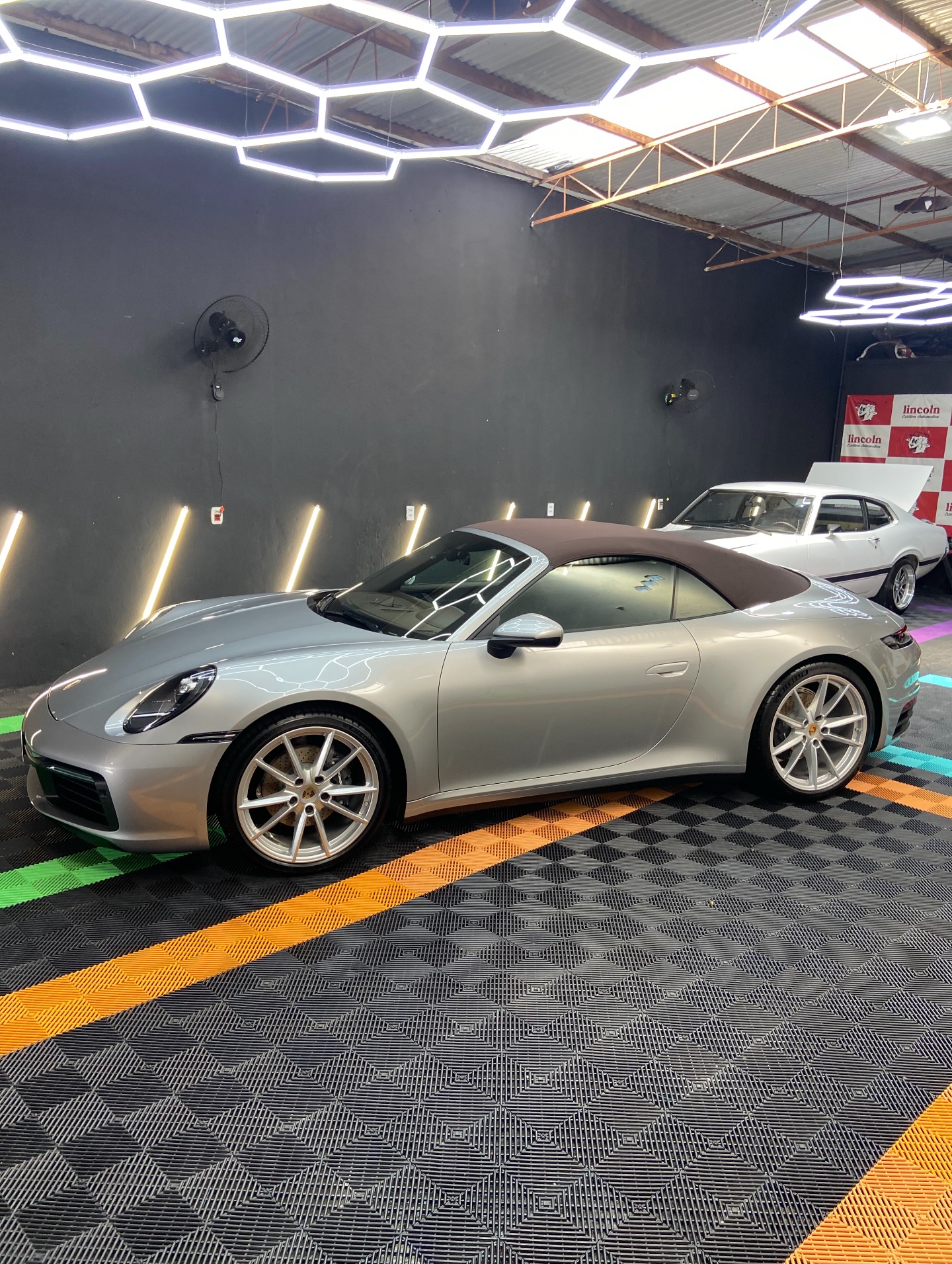 Porsche 911 Carrera prata no estúdio da 4Rodas, sob iluminação de detalhamento