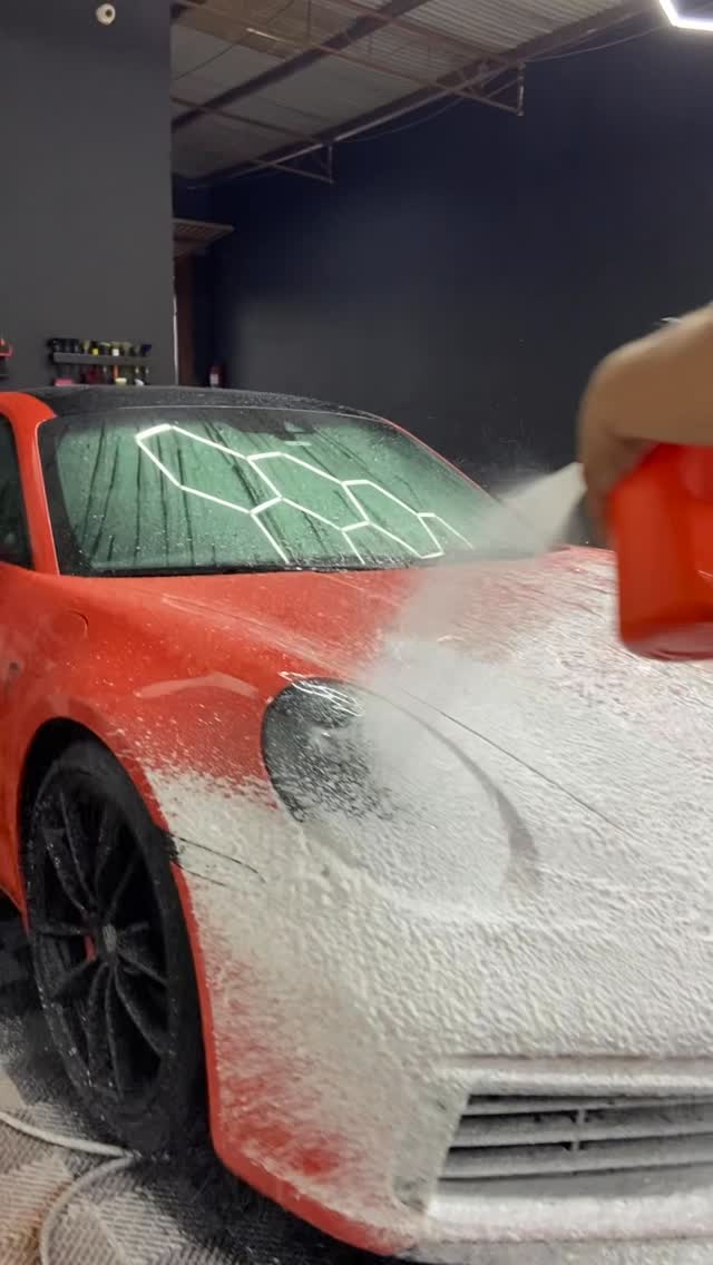 Porsche 911 vermelho durante lavagem com espuma no estúdio